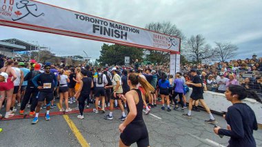 Toronto, ON, Kanada - 29 Nisan 2025: Toronto Maratonu bitiş çizgisinde büyük bir koşucu grubu toplanıyor. Çok sayıda koşucu ve dar yol geçişi imkansız kılıyor..