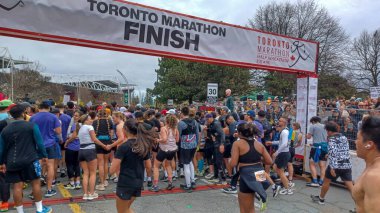 Toronto, ON, Kanada - 29 Nisan 2025: Toronto Maratonu bitiş çizgisinde büyük bir koşucu grubu toplanıyor. Çok sayıda koşucu ve dar yol geçişi imkansız kılıyor..
