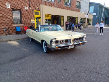 Toronto, ON, Kanada 08 Eylül 2024: Klasik bir Pontiac Parisienne üstü açık araba, insanların bir sokak etkinliği sırasında hayranlıkla izlediği gibi dükkanların önüne park ediyor..