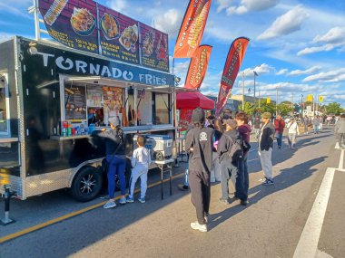 Toronto, ON, Kanada 9 Eylül 2024: İnsanlar güneşli bir öğleden sonra yemek standı, müzik ve etkinlikleriyle Kingsway Street Festivali 'nin tadını çıkarıyor..