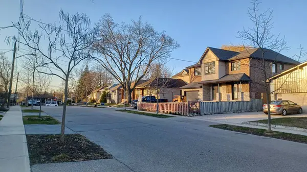 Toronto, ON, Kanada - 9 Nisan 2025: Park halindeki arabaların ve olgun ağaçların tomurcuklanmaya başladığı sakin bir yerleşim yeri..