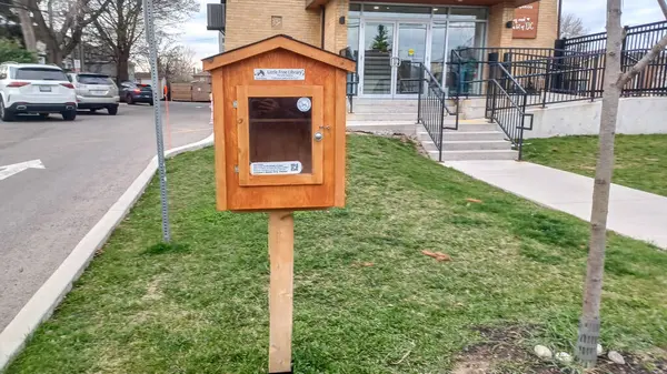 Toronto, ON, Kanada - 13 Nisan 2025: Bir yerleşim bölgesindeki kaldırım kenarında beyaz bir Serbest Kütüphane duruyor.