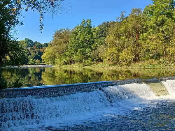 Akşam güneşi Humber Nehri somon merdivenini aydınlatıyor. İnsanlar nehir boyunca toplanıp akan suyu seyrediyorlar..