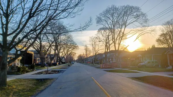 Toronto, ON, Kanada - 9 Nisan 2025: Park halindeki arabaların ve olgun ağaçların tomurcuklanmaya başladığı sakin bir yerleşim yeri..