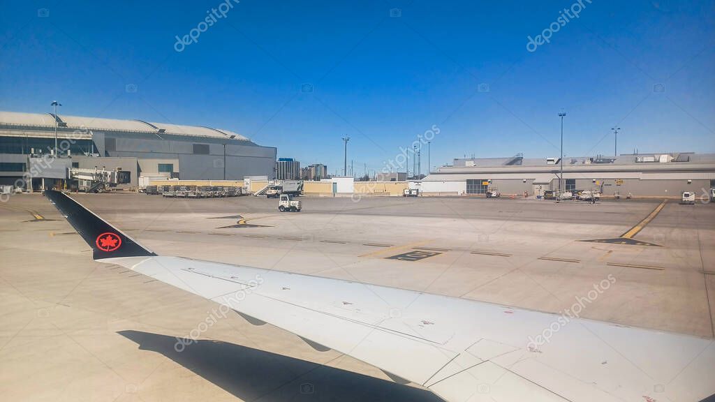 Toronto, ON, Canada - May 1, 2025: The wing and tail fin with the Air Canada maple leaf logo are visible above a layer