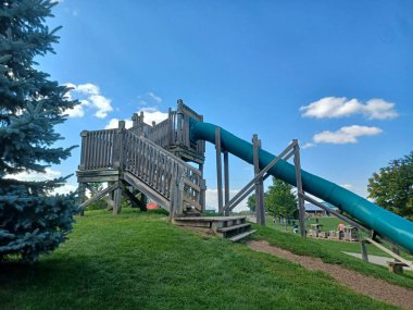 Toronto, ON, Kanada 1 Eylül 2024: Downeys Çiftliği 'nde slaytlarla ve tırmanma yapılarıyla tahta çocuk parkı çocuklara yaratıcı bir açık hava oyun alanı sunuyor..