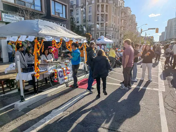 Toronto, ON, Kanada 9 Eylül 2024: İnsanlar güneşli bir öğleden sonra yemek standı, müzik ve etkinlikleriyle Kingsway Street Festivali 'nin tadını çıkarıyor..