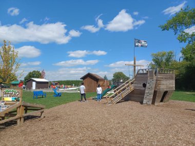 Toronto, ON, Kanada 1 Eylül 2024: Downeys Çiftliği 'nde slaytlarla ve tırmanma yapılarıyla tahta çocuk parkı çocuklara yaratıcı bir açık hava oyun alanı sunuyor..