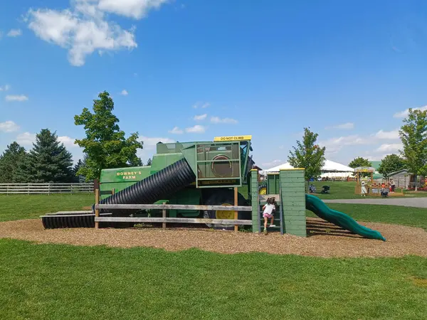 Toronto, ON, Kanada 1 Eylül 2024: Modifiye edilmiş yeşil bir John Deere biçerdöver Downeys Çiftliği 'nde çocuk parkı yapısına dönüştürüldü...