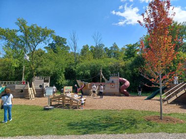 Toronto, ON, Kanada 2 Temmuz 2024: Humber Üniversitesi manzaralı Lakeshore kampüsünde ağaçlar ve yeşil çimlerle çevrili modern bir cam bina bulunuyor..