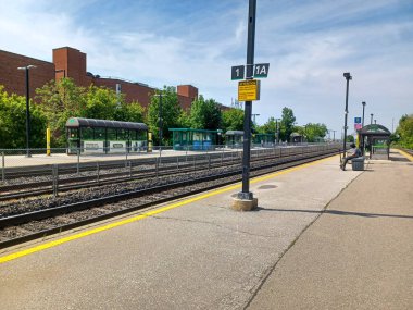 Toronto, ON, Kanada 2 Temmuz 2024: Humber Üniversitesi manzaralı Lakeshore kampüsünde ağaçlar ve yeşil çimlerle çevrili modern bir cam bina bulunuyor..