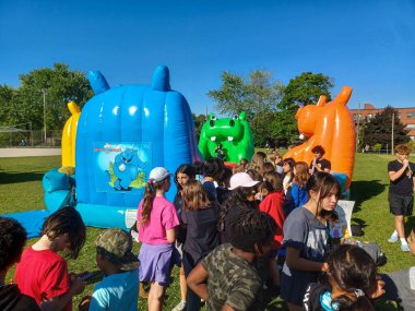 Toronto, ON, Kanada 2 Temmuz 2024: Humber Üniversitesi manzaralı Lakeshore kampüsünde ağaçlar ve yeşil çimlerle çevrili modern bir cam bina bulunuyor..