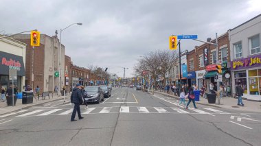 Toronto, ON, Kanada - 14 Nisan 2025: İnsanlar Durie Caddesi yakınlarındaki Bloor Caddesi boyunca 9 bahar öğleden sonra bulutlu bir gökyüzü altında yürüyüp alışveriş yapıyorlar.