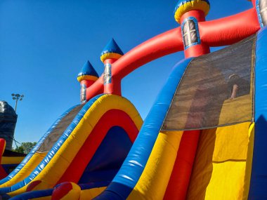 Toronto, ON, Kanada 31 Mayıs 2024: Aileler güneşli bir öğleden sonra bir çocuk etkinliğinde büyük şişme slaytlar ve engelli parkurların etrafında toplandılar..