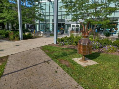 Toronto, ON, Kanada 2 Temmuz 2024: Humber Üniversitesi Öğrenci Hoşgeldin Merkezi 'nin önünde aleve benzeyen taç ve minyatür binalı küçük metal bir heykel duruyor..