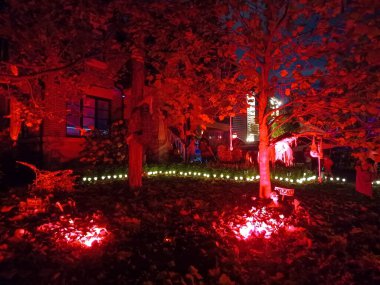 Toronto, ON, Kanada 31 Ekim 2024: Çimlerde ve balkonda parlayan Cadılar Bayramı şişme bebekleri, hayaletler, balkabakları ve ürkütücü bir ağaç...