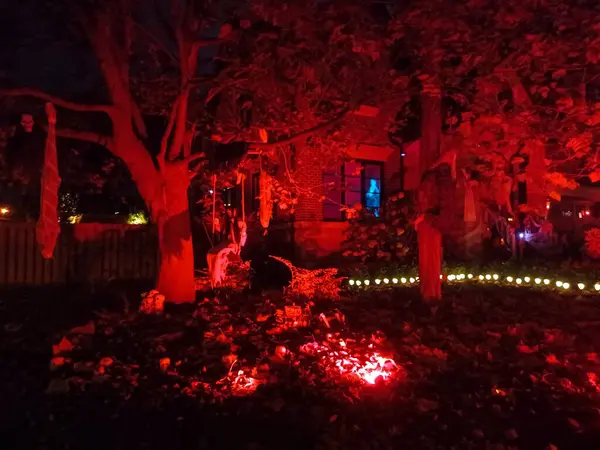 Toronto, ON, Kanada 31 Ekim 2024: Çimlerde ve balkonda parlayan Cadılar Bayramı şişme bebekleri, hayaletler, balkabakları ve ürkütücü bir ağaç...