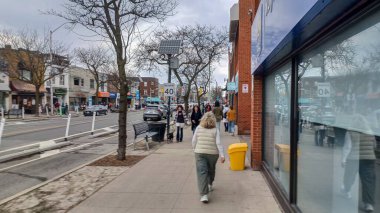 Toronto, ON, Kanada - 14 Nisan 2025: İnsanlar Durie Caddesi yakınlarındaki Bloor Caddesi boyunca 9 bahar öğleden sonra bulutlu bir gökyüzü altında yürüyüp alışveriş yapıyorlar.