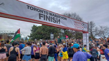 Toronto, ON, Kanada - 29 Nisan 2025: Toronto Maratonu bitiş çizgisinde büyük bir koşucu grubu toplanıyor. Çok sayıda koşucu ve dar yol geçişi imkansız kılıyor..