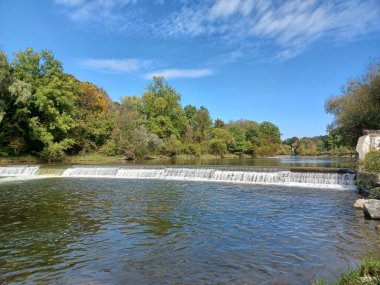 Akşam güneşi Humber Nehri somon merdivenini aydınlatıyor. İnsanlar nehir boyunca toplanıp akan suyu seyrediyorlar..