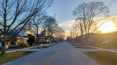 Toronto, ON, Kanada - 9 Nisan 2025: Park halindeki arabaların ve olgun ağaçların tomurcuklanmaya başladığı sakin bir yerleşim yeri..