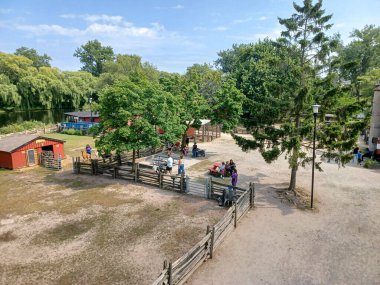 Toronto, ON, Kanada 08 Ağustos 2024: Aileler Centerville Eğlence Parkı 'nı çeşitli çocuk gezileri ve tepeden geçen bir gökdelenle keşfediyorlar..