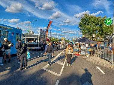 Toronto, ON, Kanada 9 Eylül 2024: İnsanlar güneşli bir öğleden sonra yemek standı, müzik ve etkinlikleriyle Kingsway Street Festivali 'nin tadını çıkarıyor..