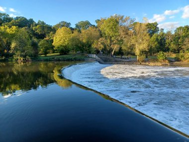 Akşam güneşi Humber Nehri somon merdivenini aydınlatıyor. İnsanlar nehir boyunca toplanıp akan suyu seyrediyorlar..