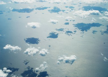 Uçsuz bucaksız mavi gökyüzü muazzam kümülüs bulutlarını ve parlak güneş ışığını sarar..