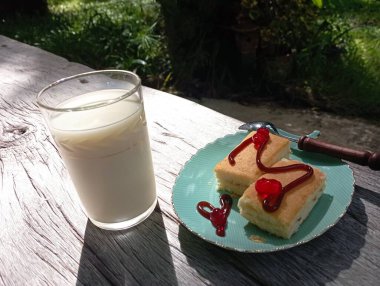 Bir fincan çay, beyaz bir tabak ve bir bardak süt.