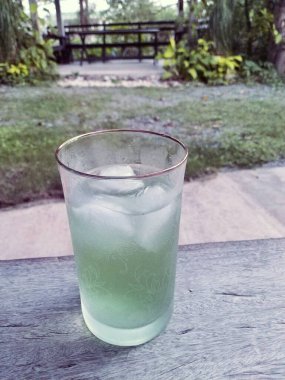 Masada buz küpleri olan bir bardak su.