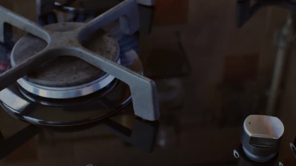 这只手关掉了现代煤气炉上的煤气 黑色燃烧器上的蓝色火焰 现代厨房使用天然燃料做饭的概念 — 图库视频影像