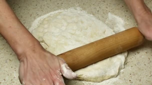 明るいキッチンテーブルの上に木製の圧延ピンで生地を圧延主婦の手のクローズアップは 白い小麦粉を振りかけた 木製の圧延ピンで生地を転がし ステップバイステップのレシピ — ストック動画