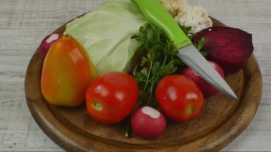 Taze çiğ ve sağlıklı sebze salatası yapmak için sebze seti. Yuvarlak kahverengi ahşap kesme tahtası ve güzelce hazırlanmış taze sebzeler. Sağlıklı yaşam tarzı.