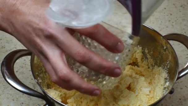 閉じる女性の手は ガラスビーカーに小麦粉を注ぐ チーズケーキのための生地を作るための混合成分を鍋に小麦粉を追加します — ストック動画