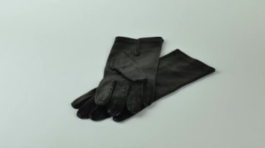 Açık arkaplanda izole edilmiş bir çift yeni siyah deri eldiven. Hafif arka planda zarif siyah deri eldivenler. Modern moda kıyafetleri konsepti.