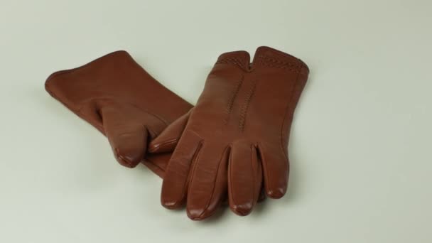 新しい茶色の革の手袋のペアは白い背景に隔離されています 優雅な女性の茶色の革の手袋白い背景に 現代のファッションウェアの概念 — ストック動画