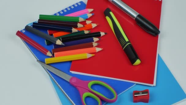 文具用品 浅色背景 一套彩色铅笔作画 两个记号 削笔机 记事本和彩纸 儿童创意办公用品的概念 平躺在床上 — 图库视频影像