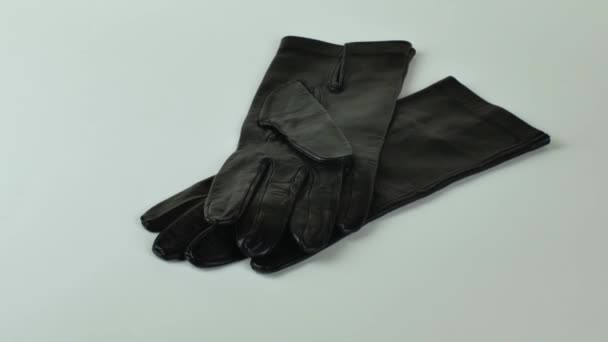 一种新的黑色皮手套 在浅色背景上隔离 浅色背景的优雅的女性黑色皮手套 现代服装的概念 — 图库视频影像