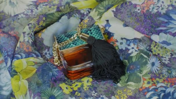 Uma Garrafa Perfume Mulheres Contexto Tecido Variegado Multicor Uma Garrafa — Vídeo de Stock