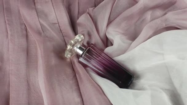 Ένα Μπουκάλι Γυναικείο Άρωμα Ένα Σκονισμένο Ροζ Φόντο Υφάσματος Ένα — Αρχείο Βίντεο