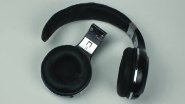 Kırık kulaklıklar arka planda izole edilmiş. Yakın çekim, üst görüş. Geri dönüşümsüz elektronik atık kavramı. Düz yatıyordu.