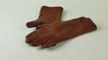 Beyaz arka planda izole edilmiş bir çift kahverengi deri eldiven. Beyaz arka planda zarif kadınların kahverengi deri eldivenleri. Modern moda kıyafetleri konsepti.