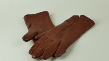 Beyaz arka planda izole edilmiş bir çift kahverengi deri eldiven. Beyaz arka planda zarif kadınların kahverengi deri eldivenleri. Modern moda kıyafetleri konsepti.