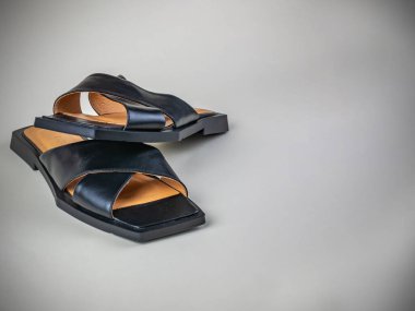 Siyahlar içinde bir çift yeni güzel kadın sandaleti. Hafif ve rahat bayan yaz sandaletleri arka planda yakın plan çekimde. Modern yaz kadın ayakkabısı kavramı..