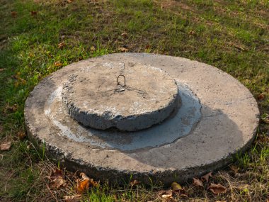 Beton bir üste yuvarlak beton rögar deliği. Şehir kanalizasyon sistemi. Beton rögar kapağı şehrin kanalizasyon sisteminin girişini kapatıyor.. 