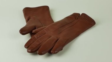 Beyaz arka planda zarif kadınların kahverengi deri eldivenleri. Beyaz arka planda izole edilmiş bir çift kahverengi deri eldiven. Soğuk mevsim için kıyafet konsepti.