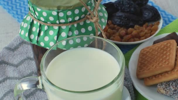 ガラス製の新鮮な天然乳 ジャムの瓶 白い小さじ1杯 ドライフルーツとソーサー クッキーとお菓子を多色のナプキンに入れました 乳製品の概念 — ストック動画