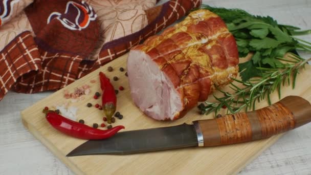 传统火腿在木制切菜板上与雕刻刀 五颜六色的调料 红辣椒 茴香和罗勒 猪肉美味肉食的概念 — 图库视频影像