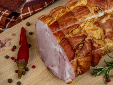 Ahşap kesme tahtasındaki geleneksel jambon, oyma bıçağı, renkli baharat, kırmızı acı biber, maydanoz, dereotu ve fesleğen. Domuz etinden lezzetli et atıştırmalıkları konsepti.